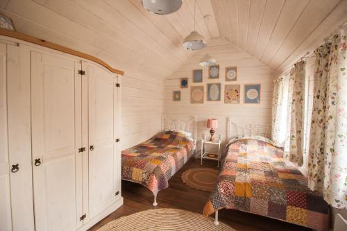 a bedroom with two beds in a room at Holiday House Folwark Jeleń in Poniklica