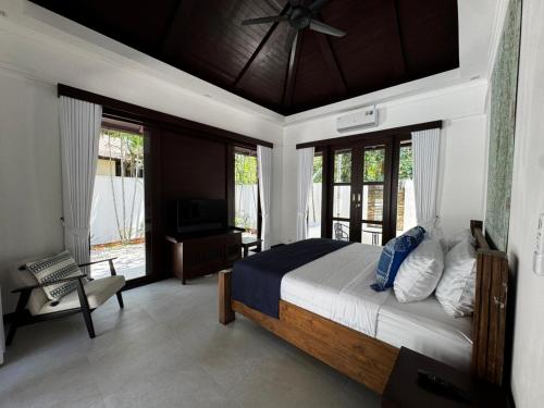 a bedroom with a bed with a ceiling fan at Villa Mirada Maenam - Renovated Four Bedroom with Private Pool in Nathon Bay