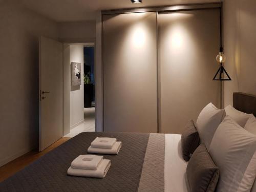a bedroom with a bed with two towels on it at FORUM Square in Skopje