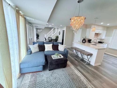 a living room with a blue couch and a kitchen at Spacious 5 Bed 2 bath House in Melrose Park