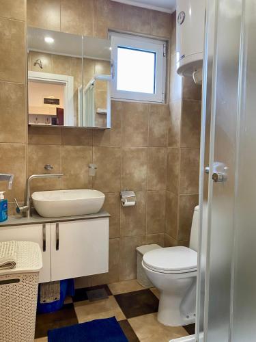 a bathroom with a toilet and a sink and a mirror at Comfort Apartment Becici in Bečići