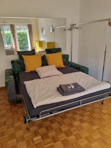 a bed in a room with yellow and green pillows at YveSkinYoga in Zurich