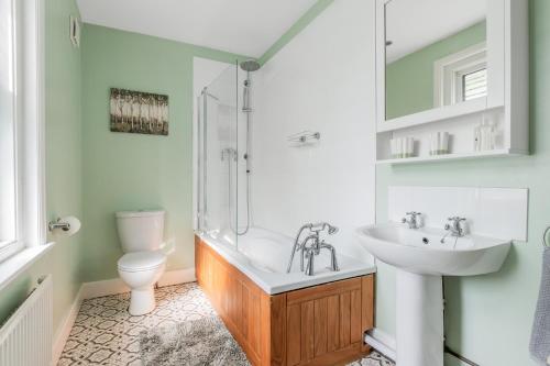 a bathroom with a sink and a shower and a toilet at Twin Tides in Hythe