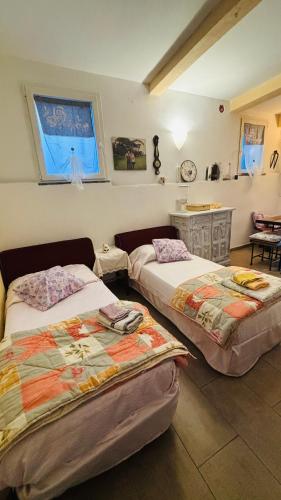 a bedroom with two beds and a table and a window at La Casa di Trilli in Moneglia