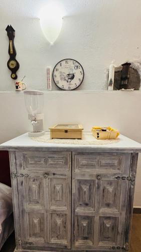 a clock on a wall next to a table with a clock on it at La Casa di Trilli in Moneglia