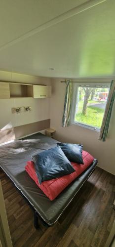 a bed in a small room with a window at Camping l'Or Bleu in Barrême