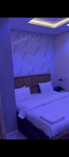 a bed with white sheets and pillows in a room at Hazie Hotel in Lagos