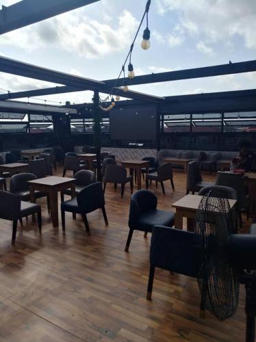 a patio with tables and chairs on a boat at Hazie Hotel in Lagos