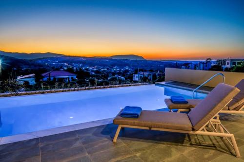 a pool with a chair and a table on a roof at Moon and Sun in Vamos