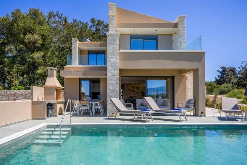 a villa with a swimming pool and a house at Moon and Sun in Vamos