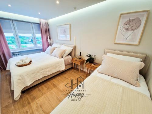 a bedroom with two beds and a window at Happy Deluxe ApartamentyHappy pl in Mielec