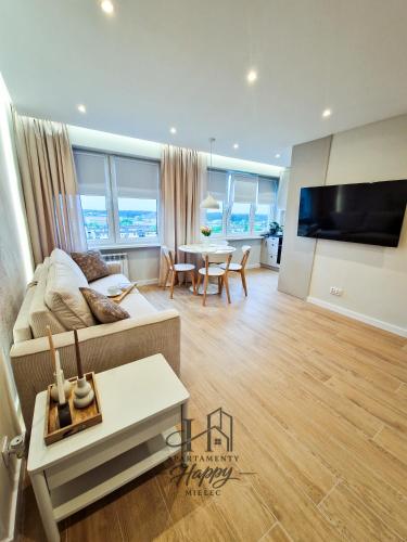 a living room with a couch and a table at Happy Deluxe ApartamentyHappy pl in Mielec