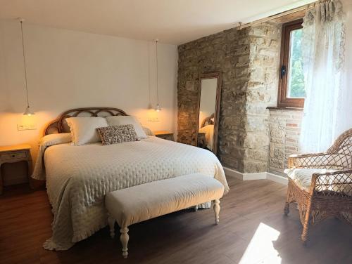 a bedroom with a bed and a stone wall at Iguzki Etxea in Urzainqui