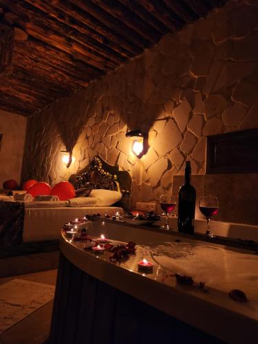 a room with a bed and a bar with wine glasses at MMF cave house in Nevşehir
