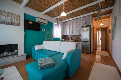 a living room with a blue couch and a kitchen at Kalypso Rental Apartment in Myloi
