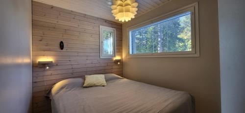 a small bedroom with a bed and a window at Syötteentupa in Syöte