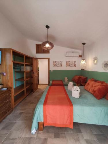 a bedroom with a large bed with a red blanket at Caribbean Lory in Puerto Viejo