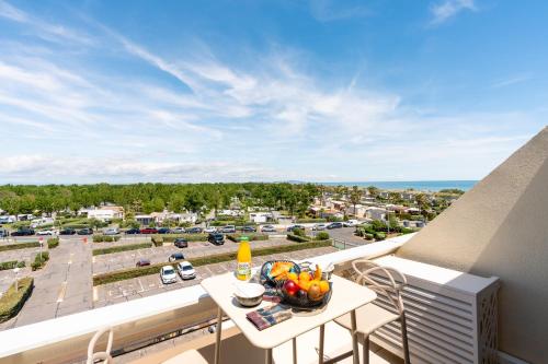 a balcony with a bowl of fruit on a table at Cap Cosy studio standing Naturiste Heliopolis Cap d'Agde with Sea View in Cap d'Agde