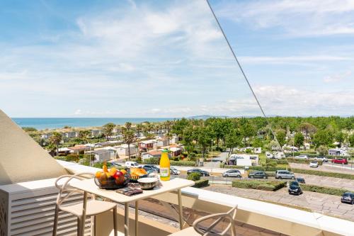 a balcony with a table and chairs and a view of the ocean at Cap Cosy studio standing Naturiste Heliopolis Cap d'Agde with Sea View in Cap d'Agde