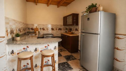 a kitchen with a refrigerator and two bar stools at Quiet Mini Villa with Garden in Luxor