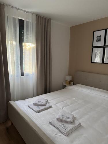a bedroom with a white bed with two towels on it at Aeri Nature Concept in Baljevac