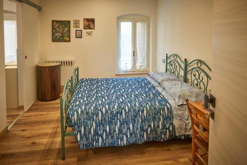 a bedroom with a bed with a blue comforter at B&Bee alla corte in Dossobuono