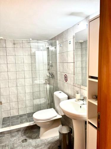 a bathroom with a toilet and a sink at Andreana's Place Rhodes in Asgourou