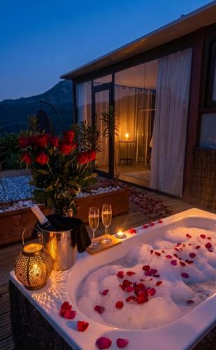 a bath tub filled with red roses and wine glasses at DDG Retreat in Casares