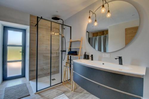 a bathroom with a sink and a mirror at Maison de Charme avec Spa Privatif & Jardin en Pleine Nature - Plages à moins de 20min in Guerlesquin