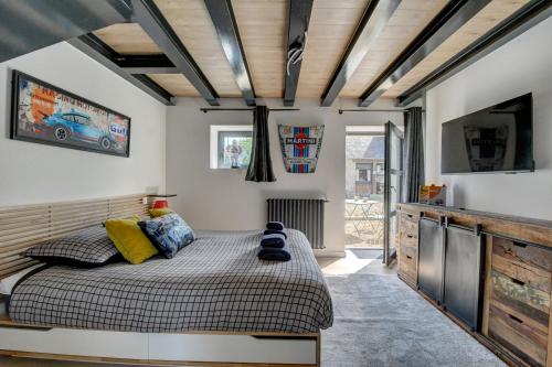 a bedroom with a bed and a flat screen tv at Maison de Charme avec Spa Privatif & Jardin en Pleine Nature - Plages à moins de 20min in Guerlesquin