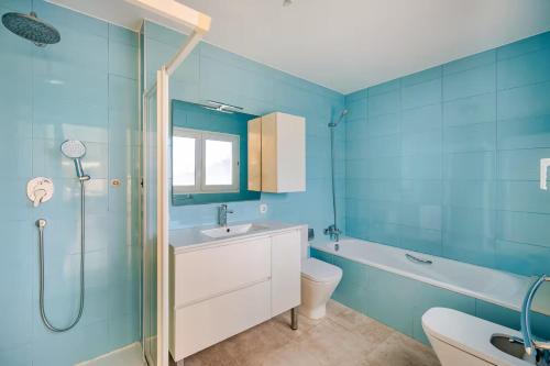 a blue bathroom with a sink and a toilet and a shower at Beachfront Villa in Moraira