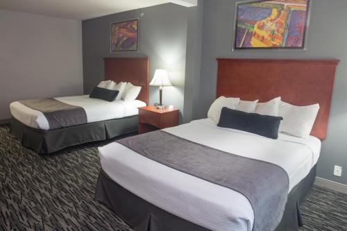 a hotel room with two beds and two lamps at Parke Regency Hotel & Conference Center in Bloomington