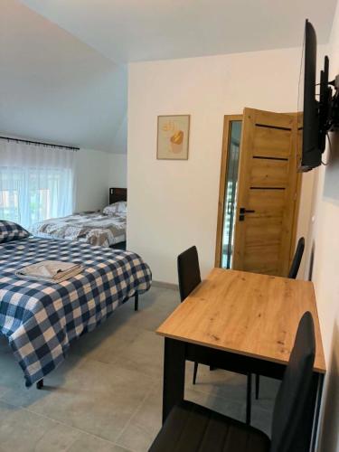 a bedroom with a bed and a table and a desk at pokoje do wynajęcia in Grajewo