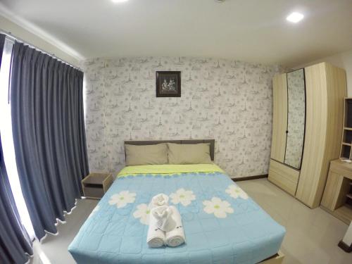 a bedroom with a blue bed with white shoes on it at Me Condo by SN in Rayong