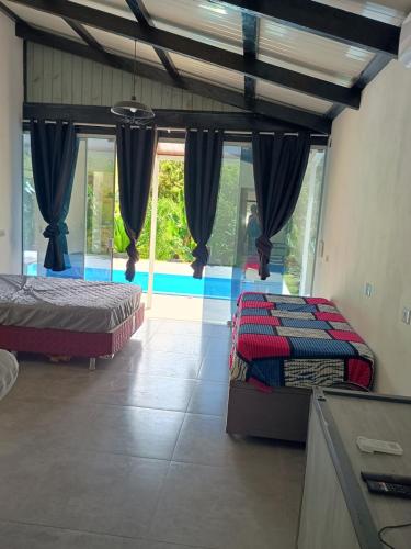 a bedroom with two beds and a large window at La casa de vidro in Tijucas