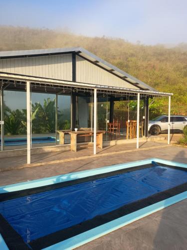 a swimming pool in front of a house at La casa de vidro in Tijucas