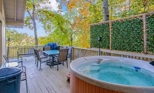 a hot tub on a deck with a table and chairs at The Safari Lodge in Osage Beach