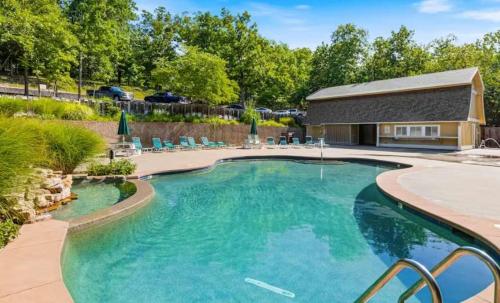 a swimming pool with blue water in a yard at The Safari Lodge in Osage Beach
