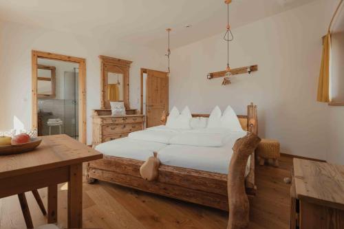 a bedroom with a large bed and a table at Bucherhof in Marlengo
