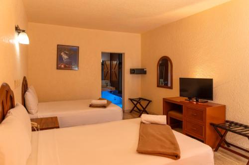 a hotel room with two beds and a television at Eurohotel in Ciudad del Carmen