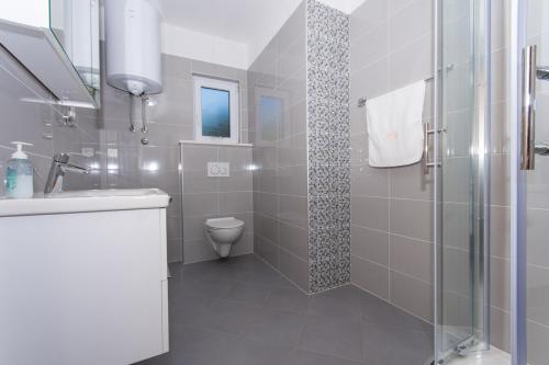 y baño con ducha, lavabo y aseo. en Apartmani Gaube en Trogir