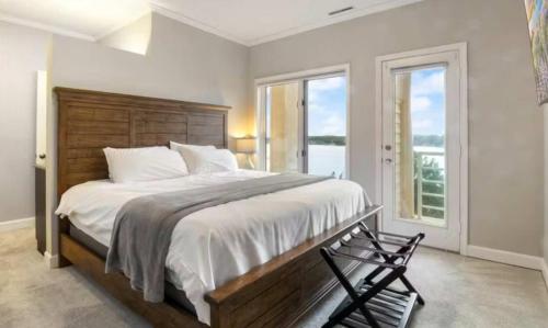 a bedroom with a large bed and two windows at Emerald Bay Unit 1B in Lake Ozark