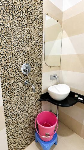 a bathroom with a sink and a wash basin at Hotel City Palace in Varanasi