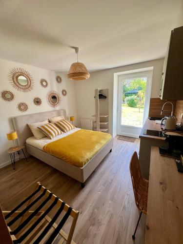 a bedroom with a bed and a window and a mirror at L'Escale d'Armorique 1 in Languidic