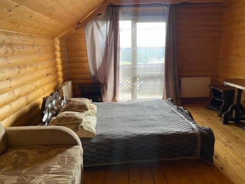 two beds in a wooden room with a window at Chalet Trushnyi in Palyanytsya