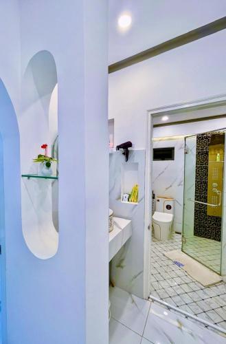 a white bathroom with a shower and a toilet at Hoàng Nga 1 Apartment in Phan Thiet