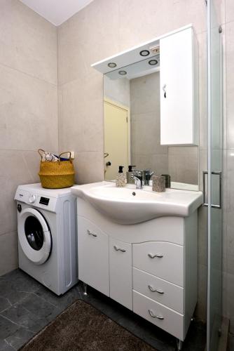 a bathroom with a sink and a washing machine at Stegna Holiday 2 in Archangelos