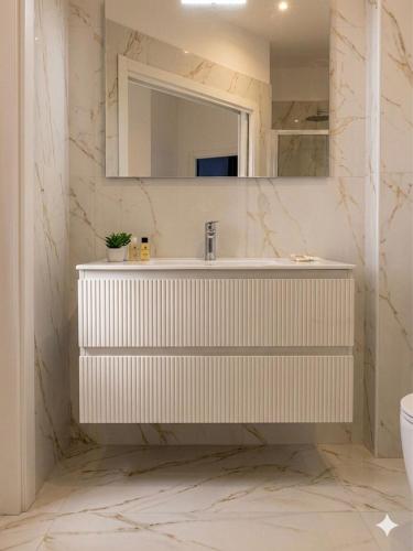 a white bathroom with a sink and a mirror at Partenopeo Rooms & Suite in Nola