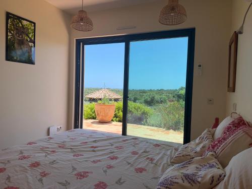 a bedroom with a bed and a large sliding glass door at Casa Poupa in Lagoa