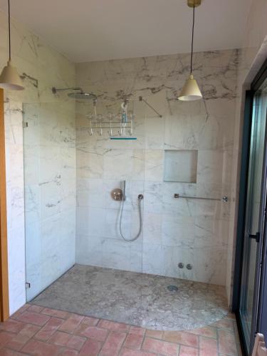 a bathroom with a shower with a glass door at Casa Poupa in Lagoa